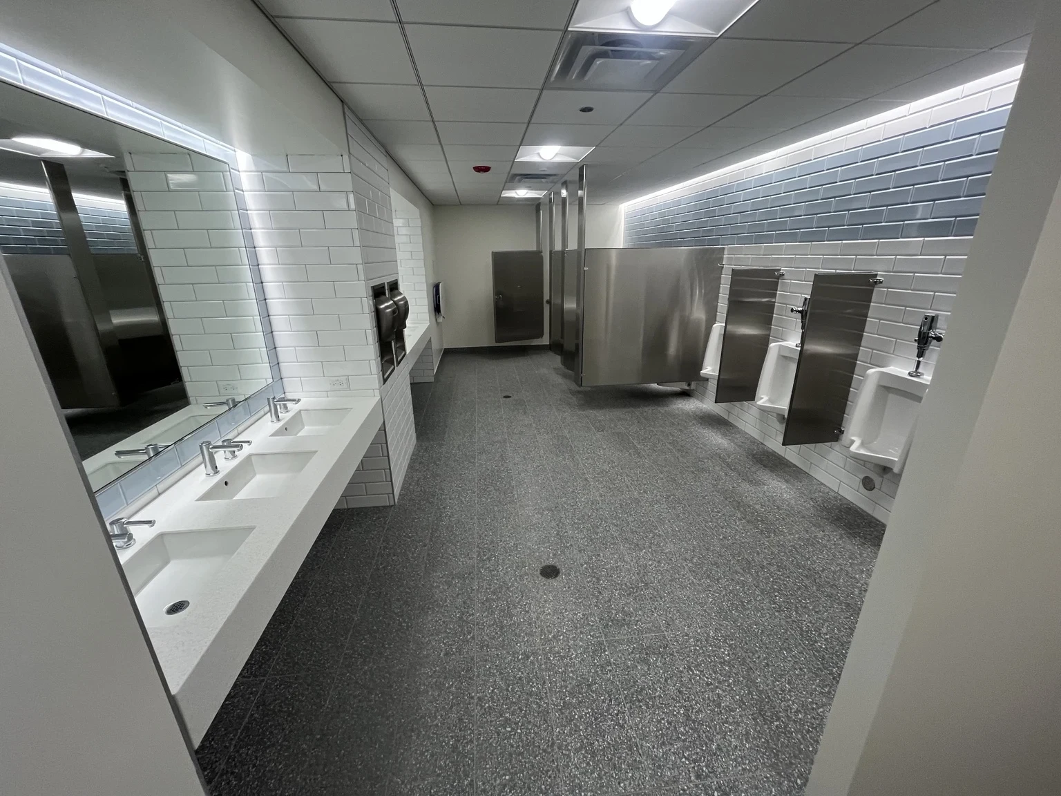 Restroom interior with illuminated mirrors and ceiling lights at Altitude Chicago.