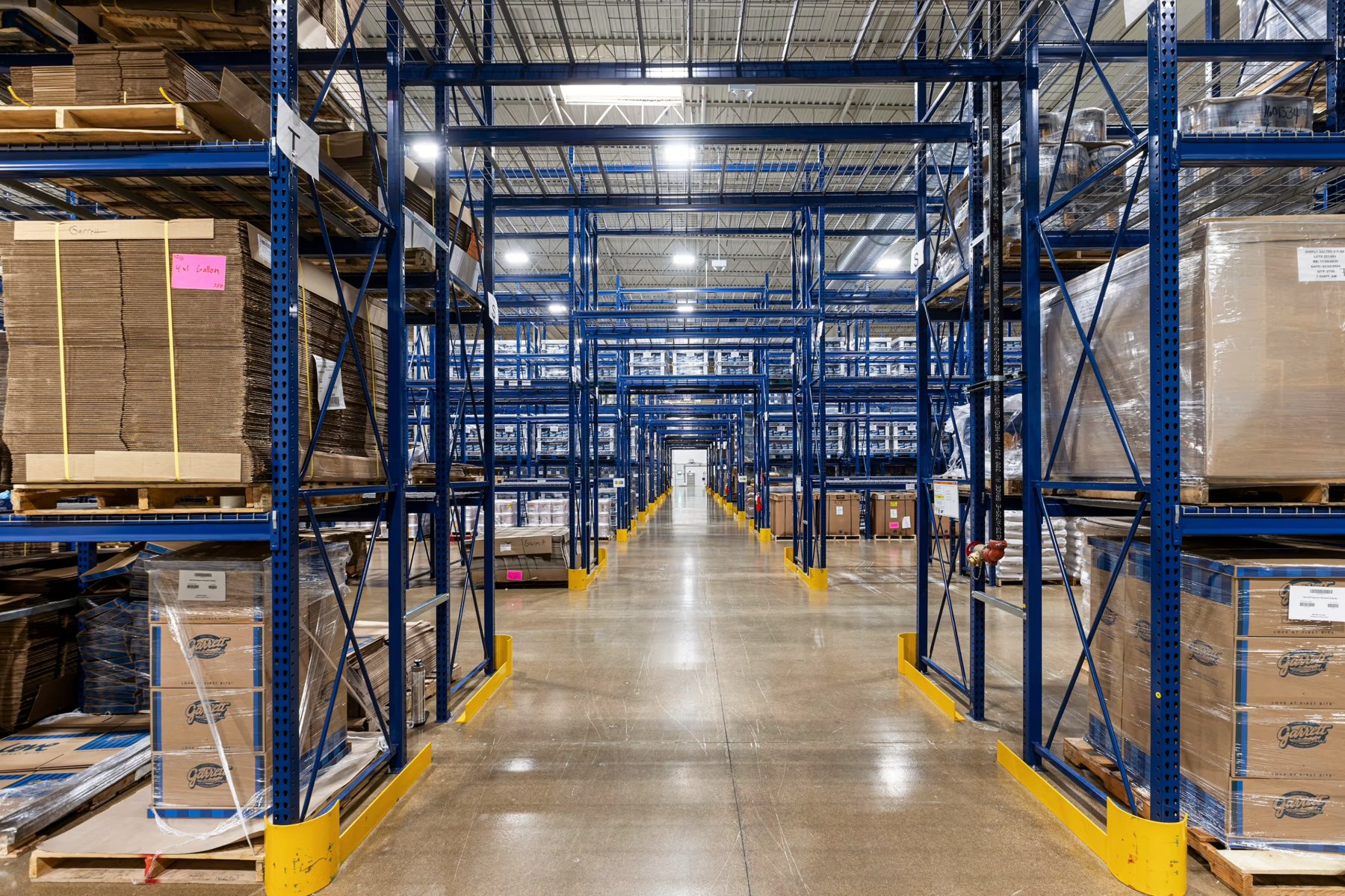 Overhead lighting above storage racks and an aisle at Garrett Popcorn Warehouse in Aurora, Illinois.