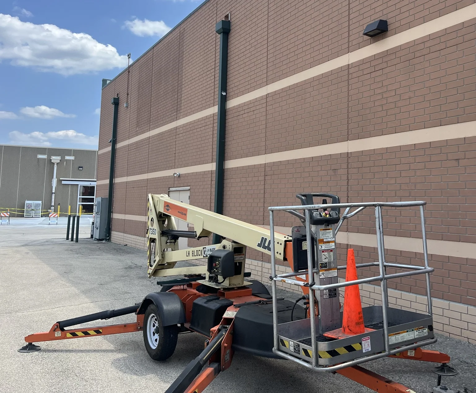 LH Block lift positioned beside the building during exterior lighting work.