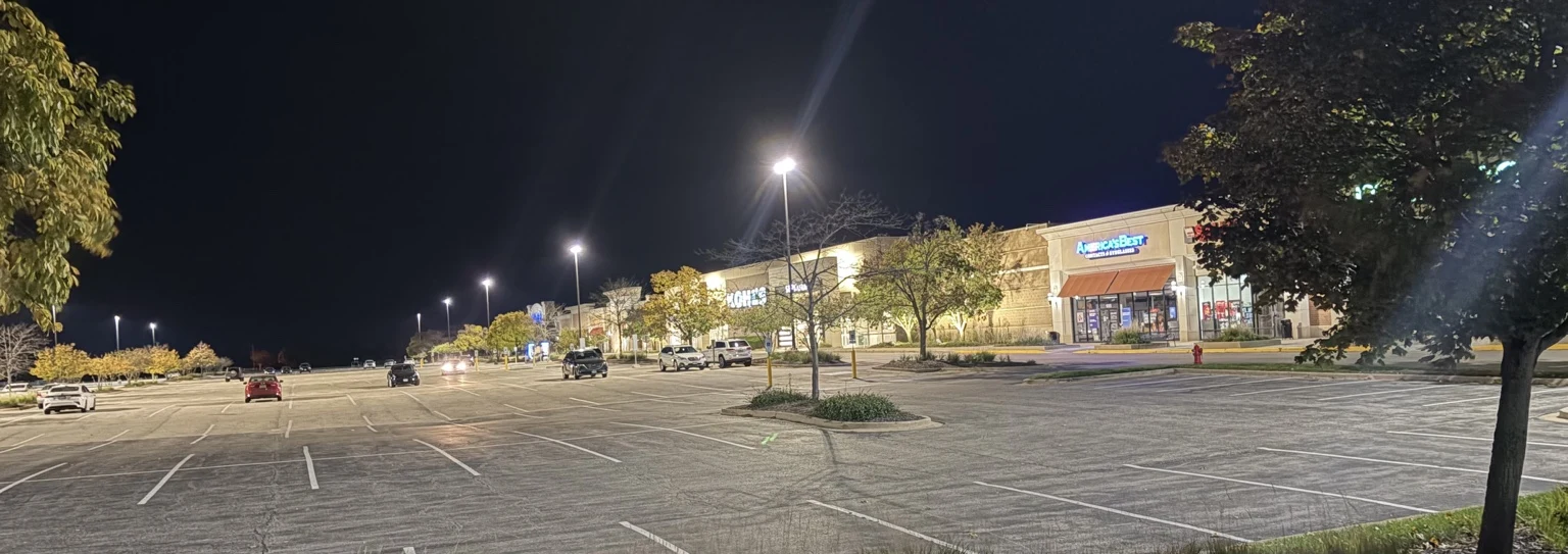 Parking-lot lighting and storefronts at Kendall Marketplace after dark.