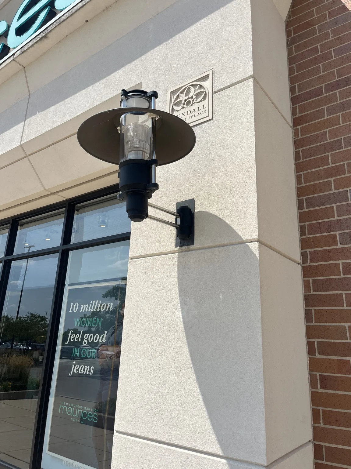 Decorative wall sconce beside the Kendall Marketplace architectural plaque.