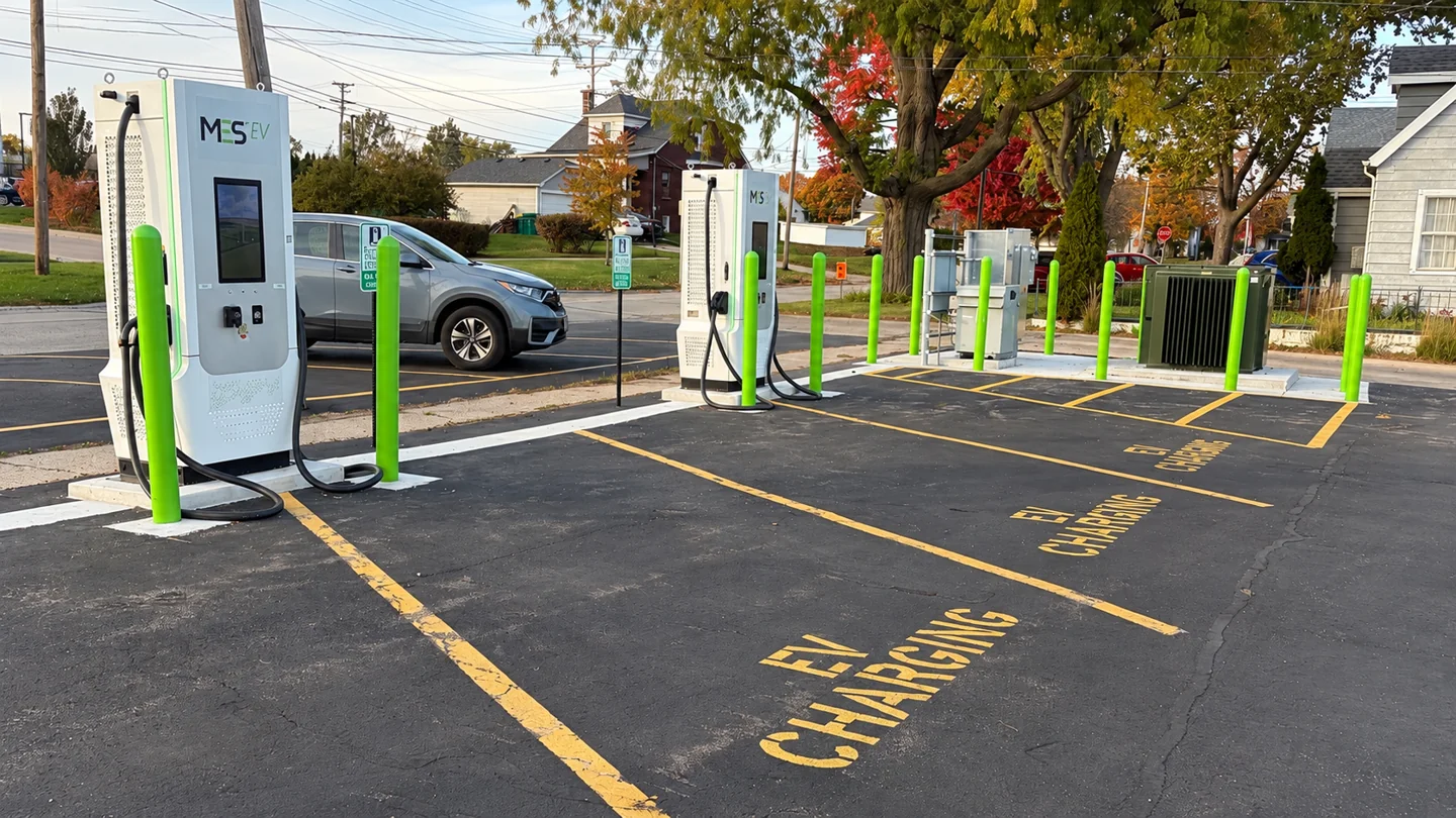 Two DC fast chargers, designated EV parking spaces, and electrical service equipment at the Sycamore charging site.
