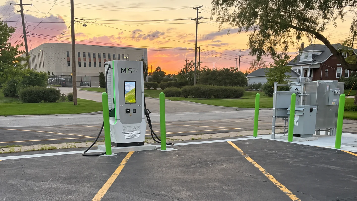 EV fast charger and outdoor electrical equipment at sunset.