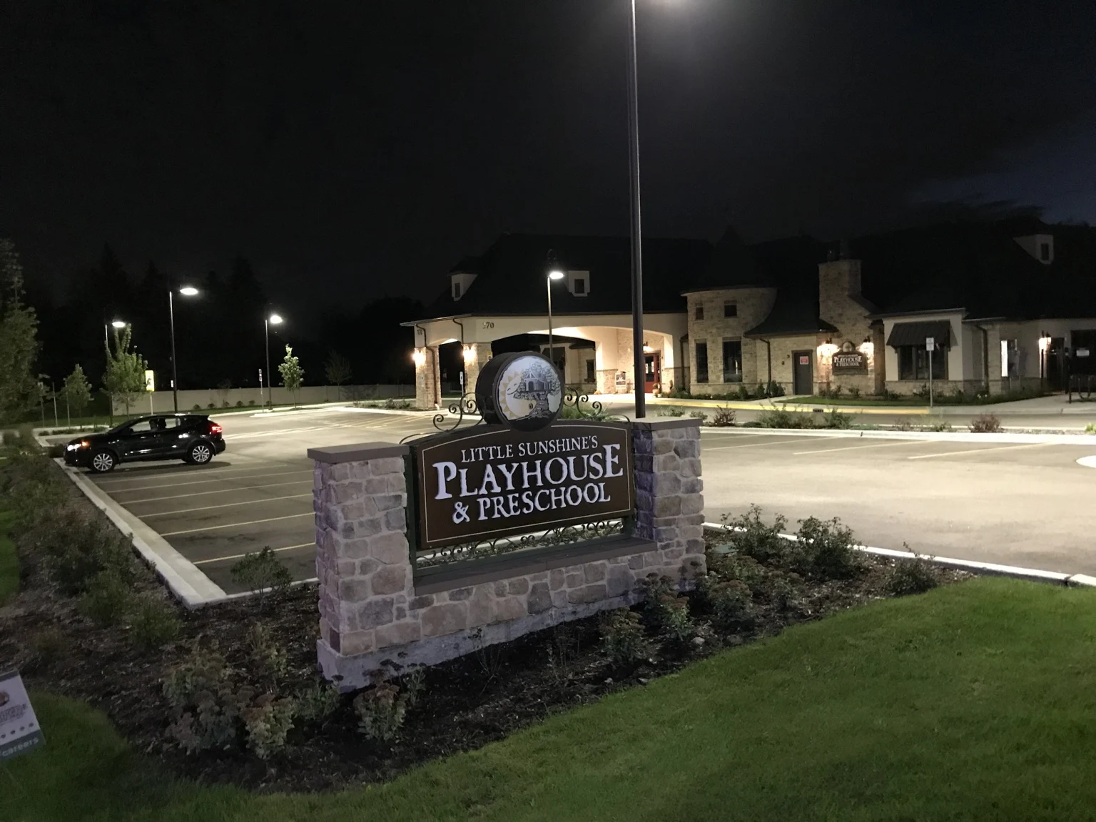 Entrance and parking-area lighting after dark.