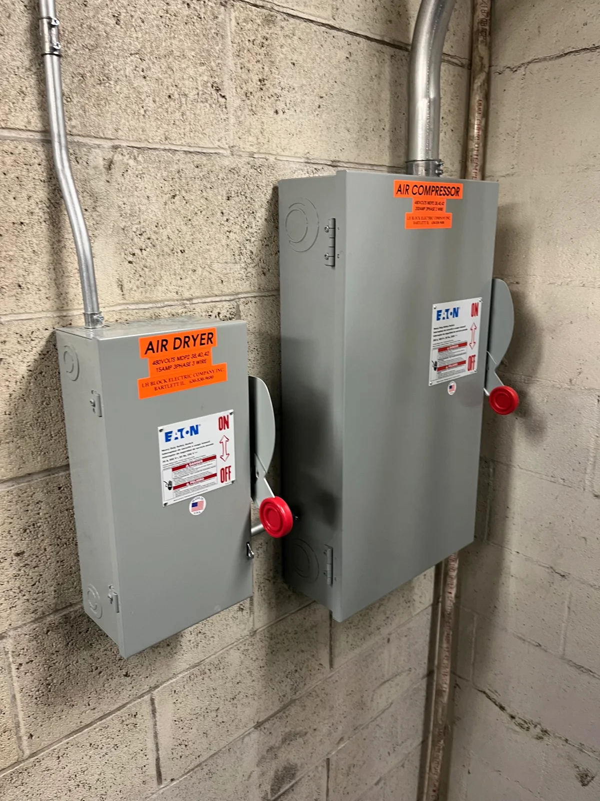 Wall-mounted disconnect switches labeled air compressor and air dryer.