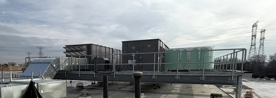 Large rooftop HVAC equipment and ductwork on a raised steel platform.
