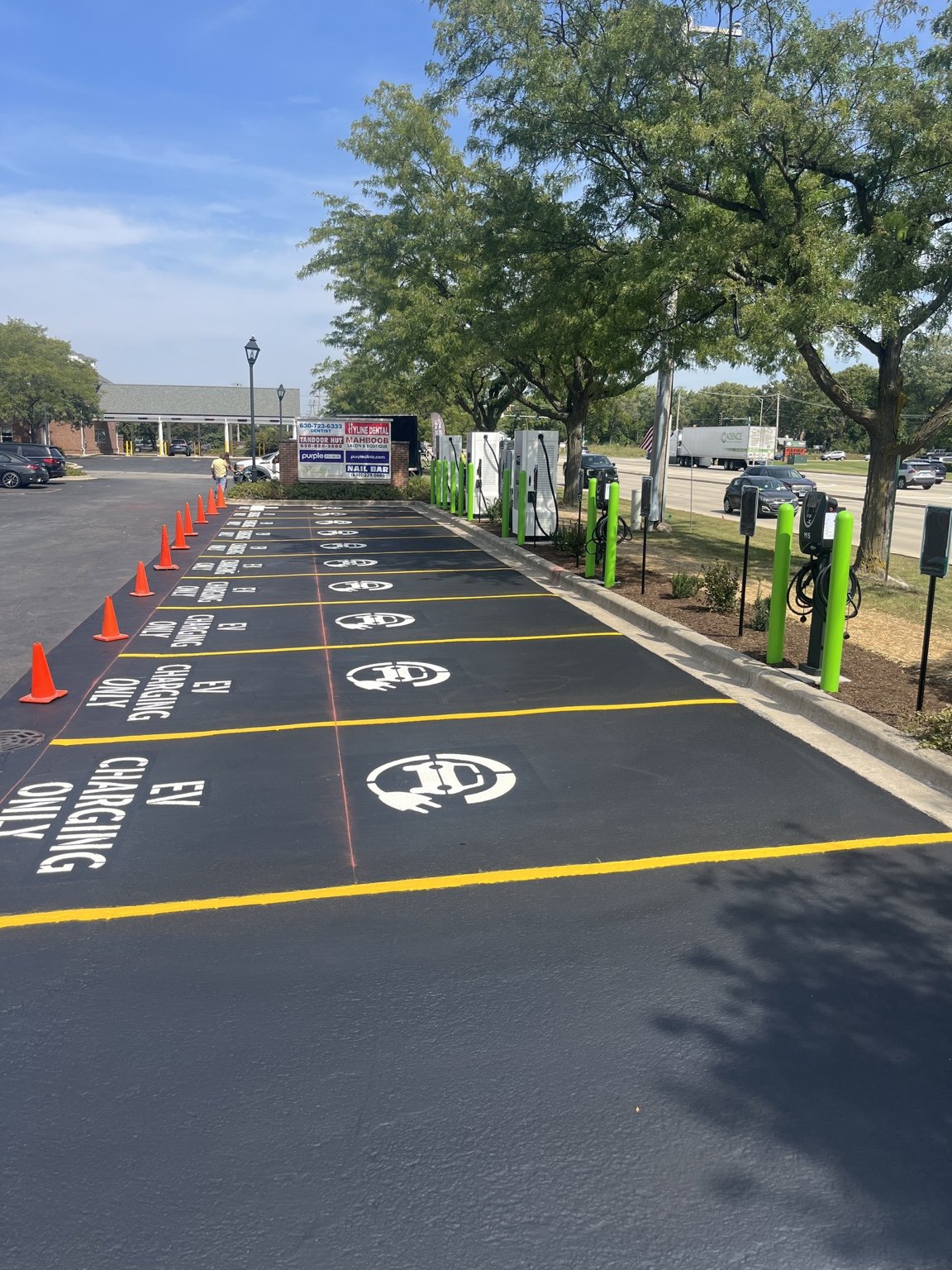 Designated EV charging spaces with yellow lines and parking symbols in Naperville.