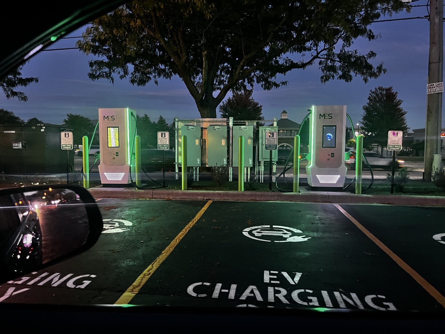 Naperville EV charging stations illuminated at night beside marked parking spaces.