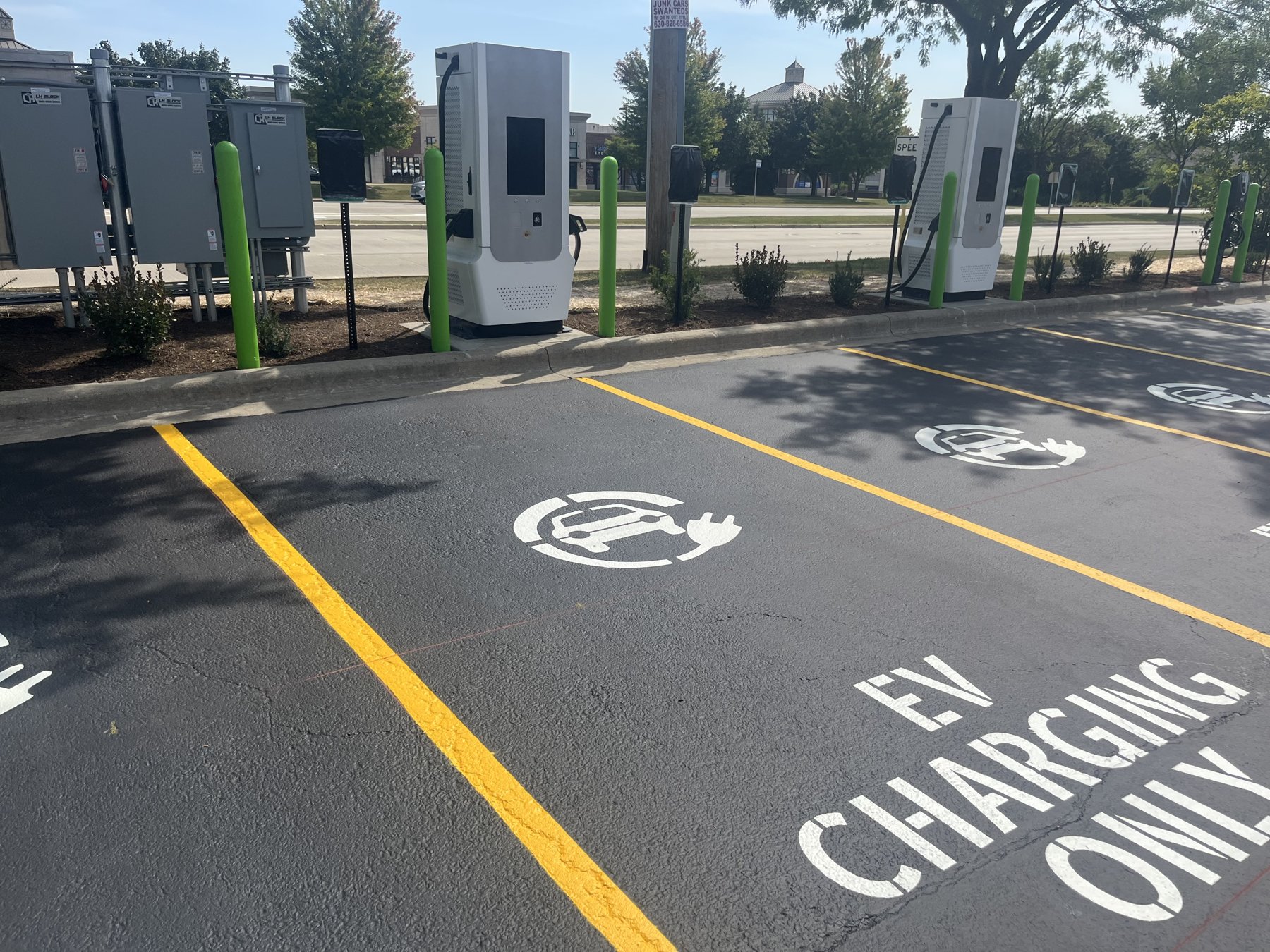 EV charging stations, green protective bollards, and marked parking spaces in Naperville, Illinois.