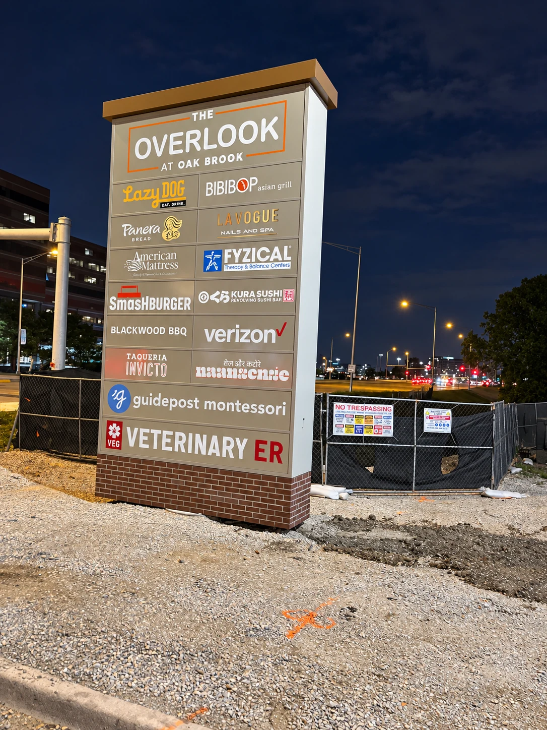 Illuminated Overlook at Oak Brook monument sign at night.