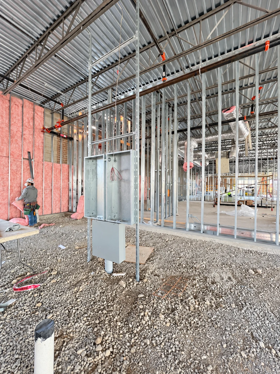Electrical panel enclosure and conduit installed within metal framing during shell construction.