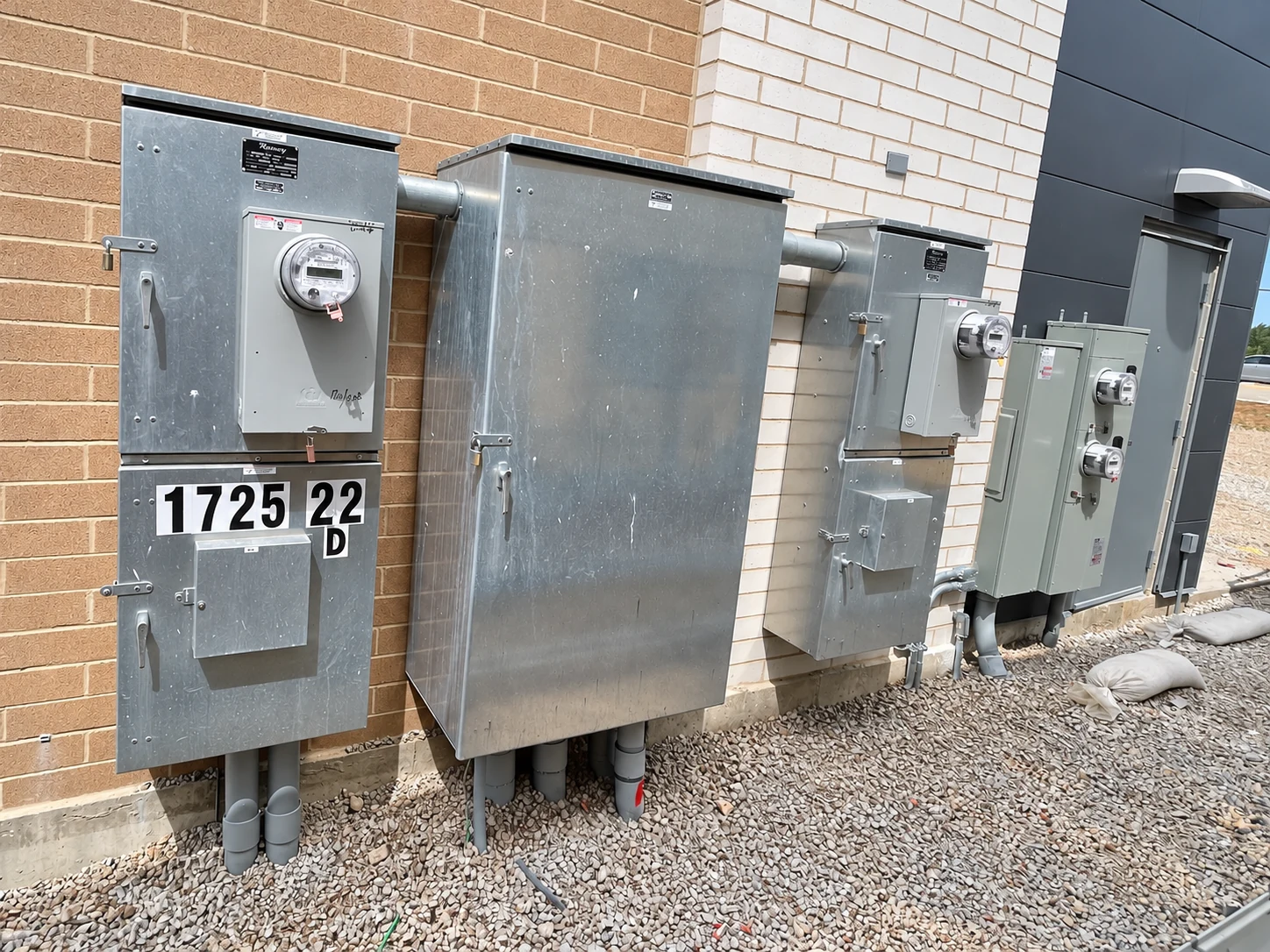 Exterior metering and service equipment installed beside a commercial building.