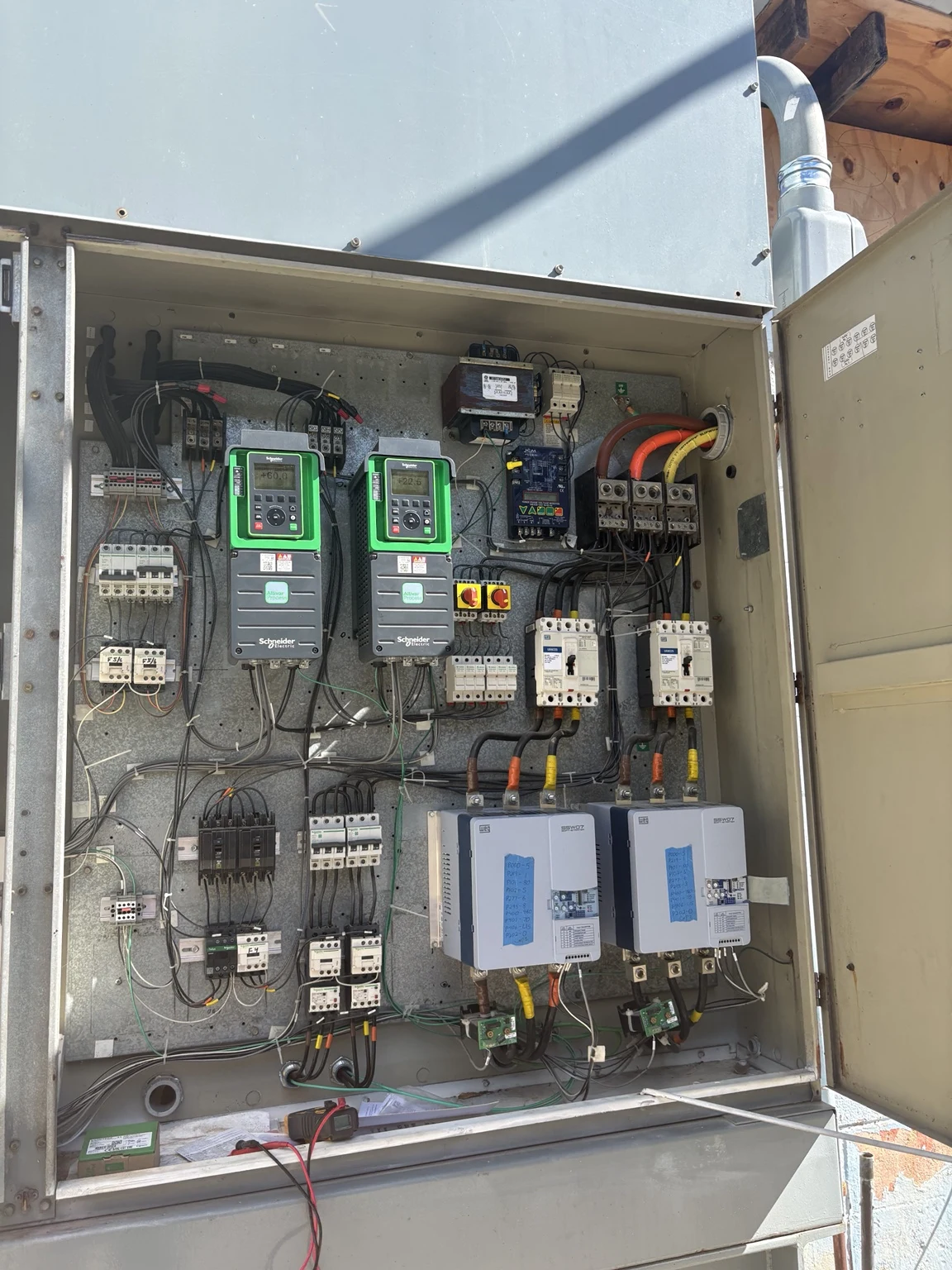 Variable frequency drives and components inside the ice-making equipment control enclosure.