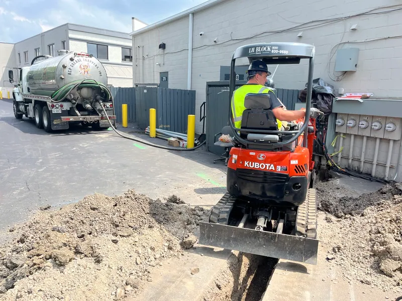 Excavation beside the meter bank while activity continued in the rear service drive.
