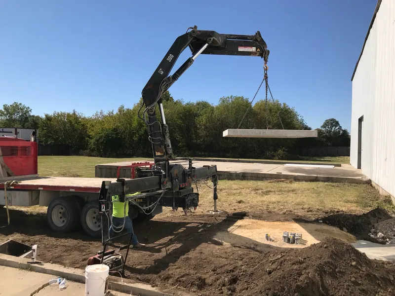 Placement of the precast concrete transformer pad during construction.