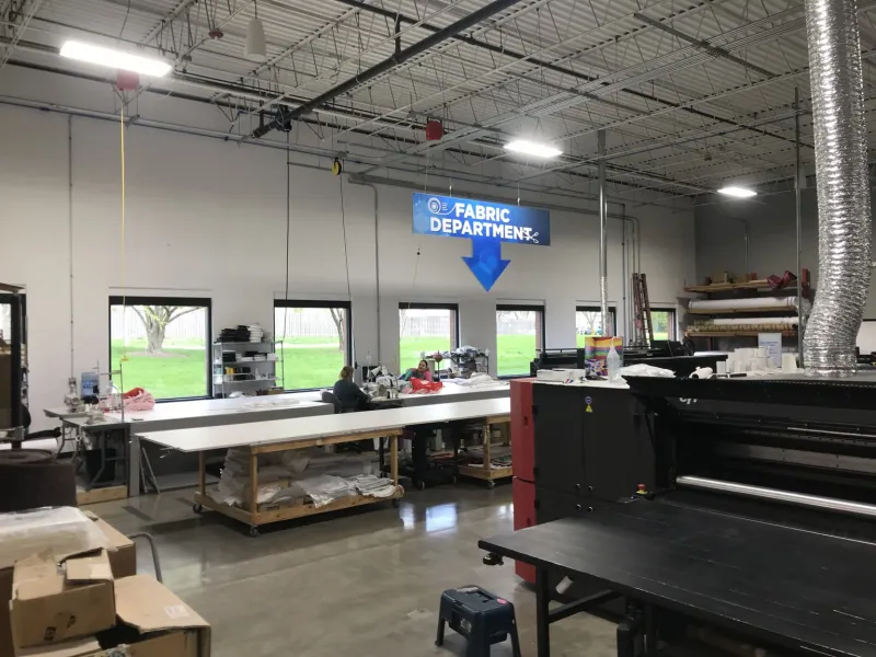 Illuminated fabric production area with worktables and printing equipment