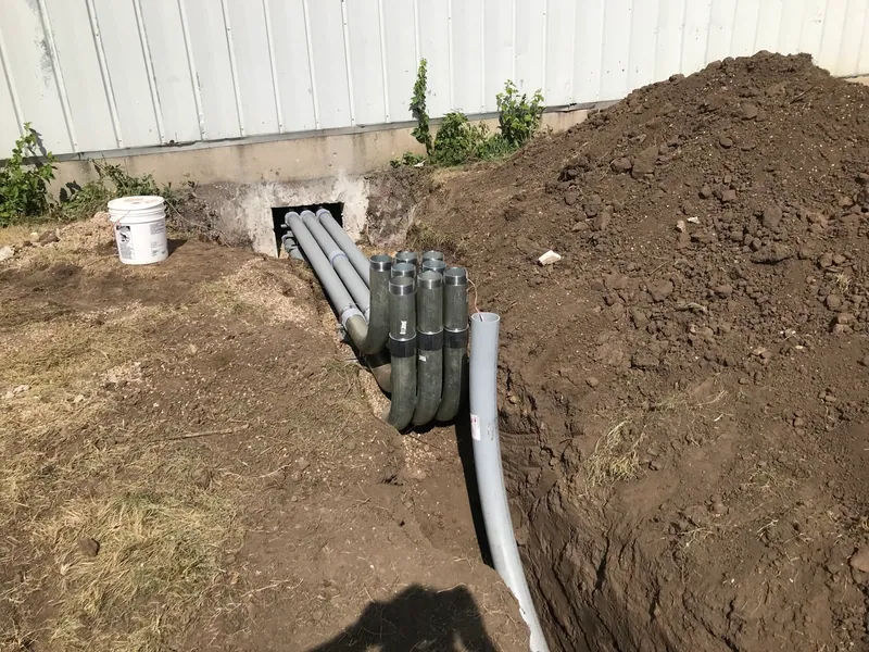 Underground service conduits routed between the transformer location and the building.