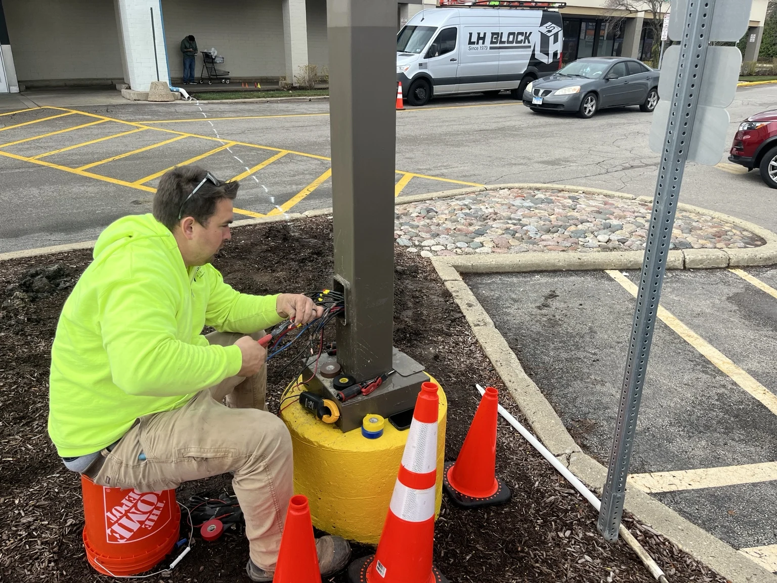 Electrical troubleshooting and connections at a parking-lot light pole.