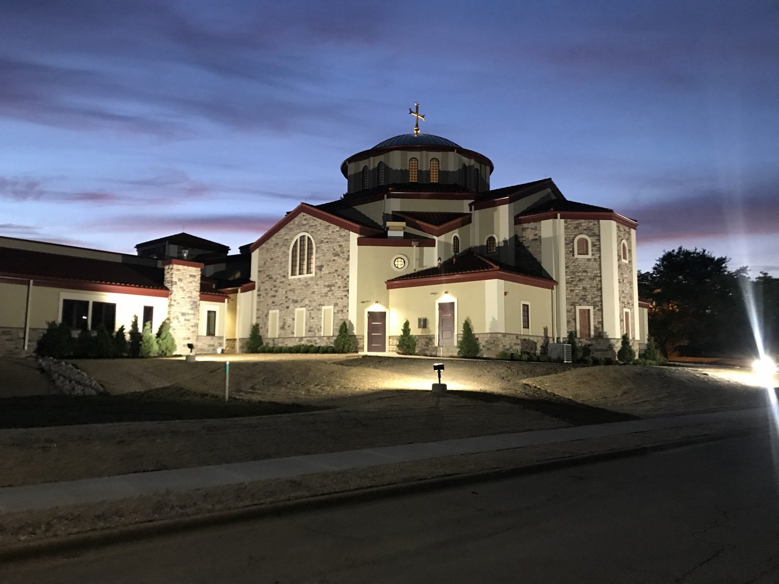 Wide evening view of the illuminated exterior of St. Sophia Greek Orthodox Church.