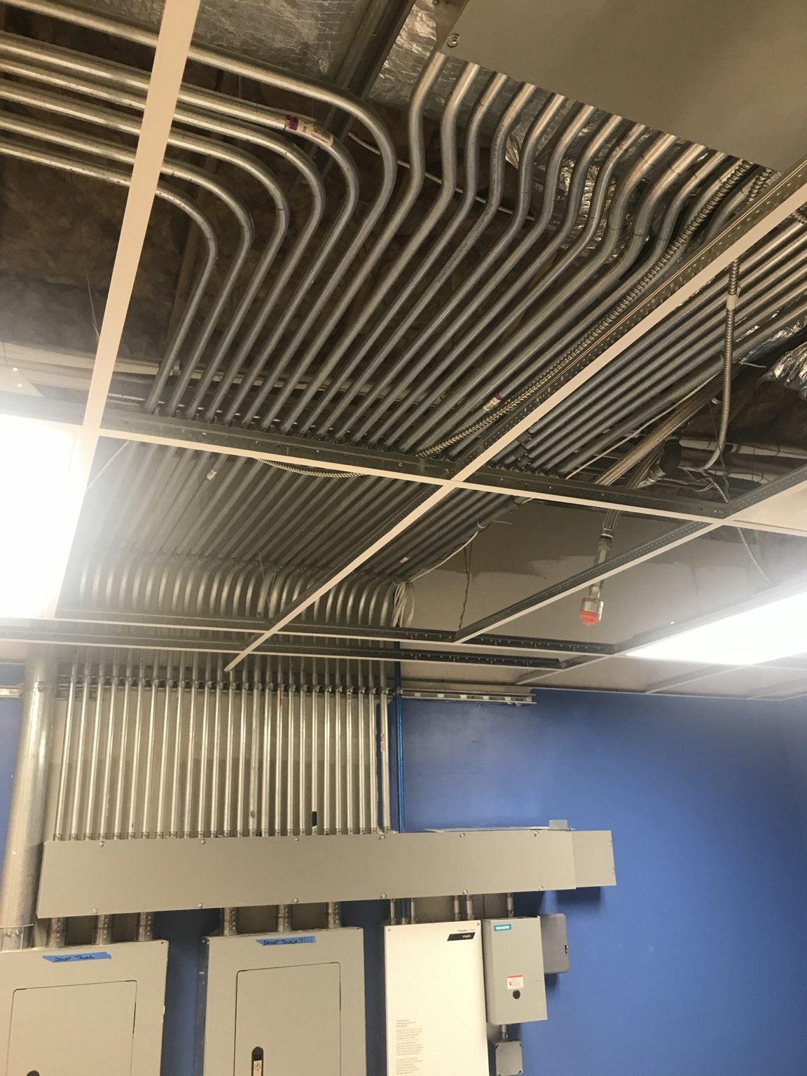 Electrical conduit routed across the ceiling and down toward panels at St. Sophia.