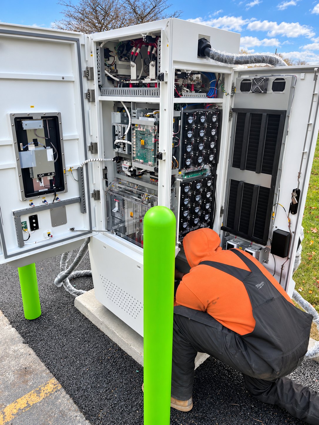 A worker at an open EV charging cabinet during the Villa Park installation.