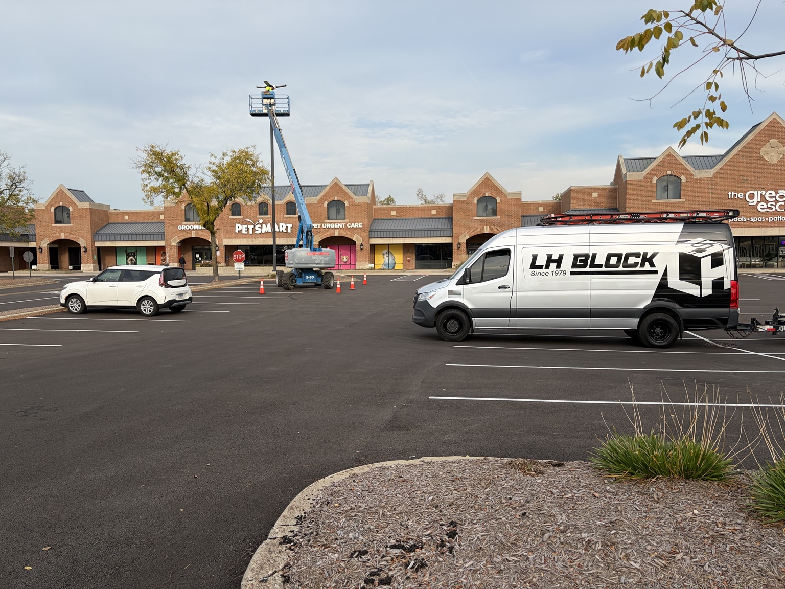 LH Block Electric service van and crew installing parking-lot lighting at Village Square.